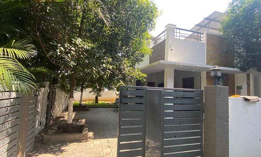 Walk through a scenic entrance surrounded by greenery and feel the atmosphere at farmhouse in Sulur.