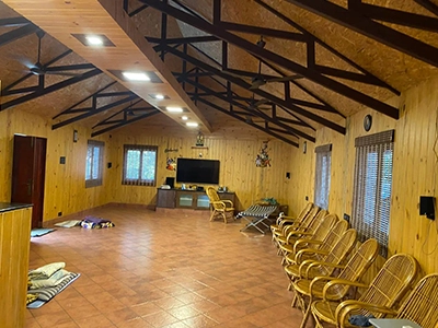 Relax in a large, well-lit living hall featuring cozy wooden décor at a private farmhouse stay Sulur.