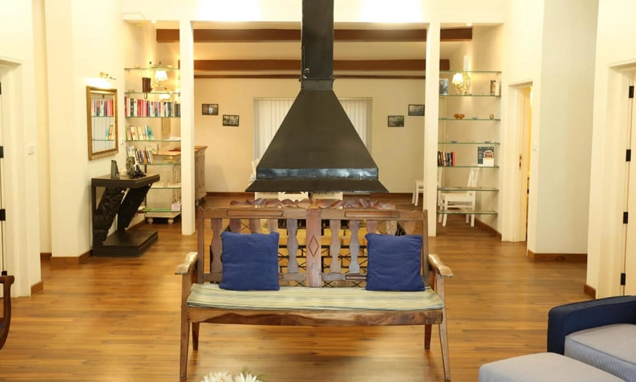 Relax by the cozy fireplace in this bright lounge with wooden floors and warm seating Rayne Forest Kotagiri