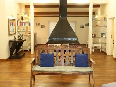 Relax by the cozy fireplace in this bright lounge with wooden floors and warm seating Rayne Forest Kotagiri