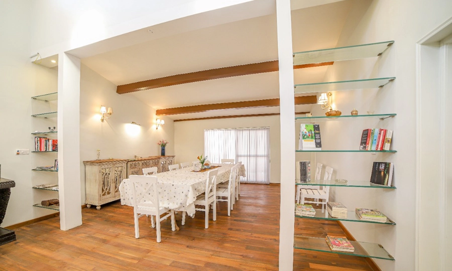 Gather for delicious meals in this warm, spacious dining room with books and bright decor Rayne Forest Kotagiri.
