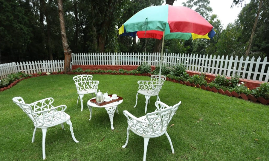 Enjoy warm tea moments in a cozy garden corner with fresh air and relaxed outdoor seating in Rayne Forest Kotagiri.