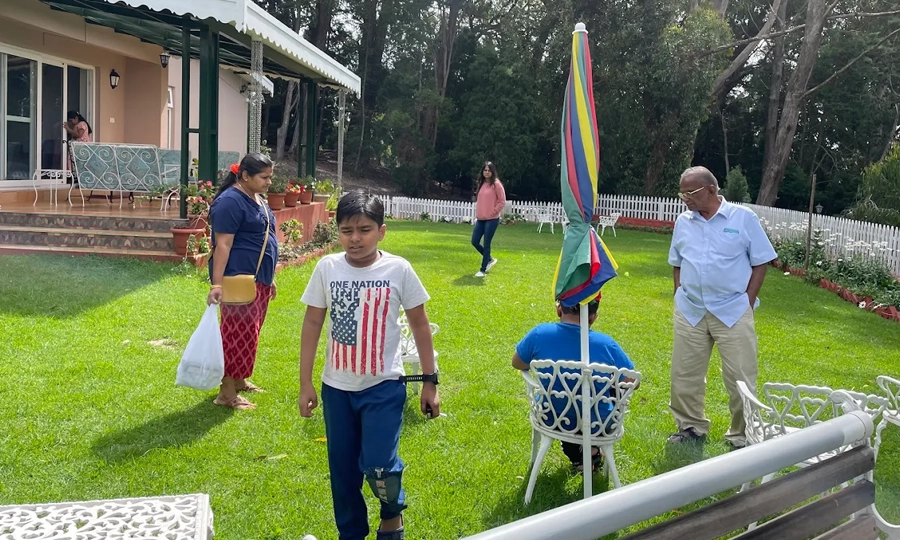 Enjoy family moments in a lush green garden lawn with outdoor seating and trees Rayne Forest Kotagiri