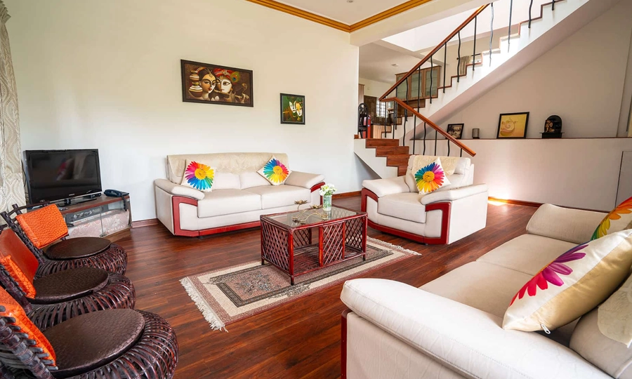 Relax in a modern villa living room featuring a sleek TV unit, cozy seating, and stylish wall frames in Kotagiri.