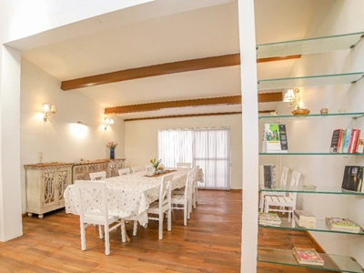 Gather for delicious meals in this warm, spacious dining room with books and bright decor Rayne Forest Kotagiri.