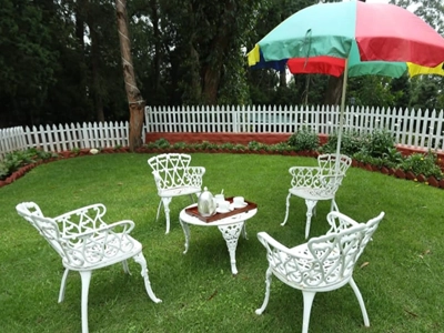 Enjoy warm tea moments in a cozy garden corner with fresh air and relaxed outdoor seating in Rayne Forest Kotagiri.